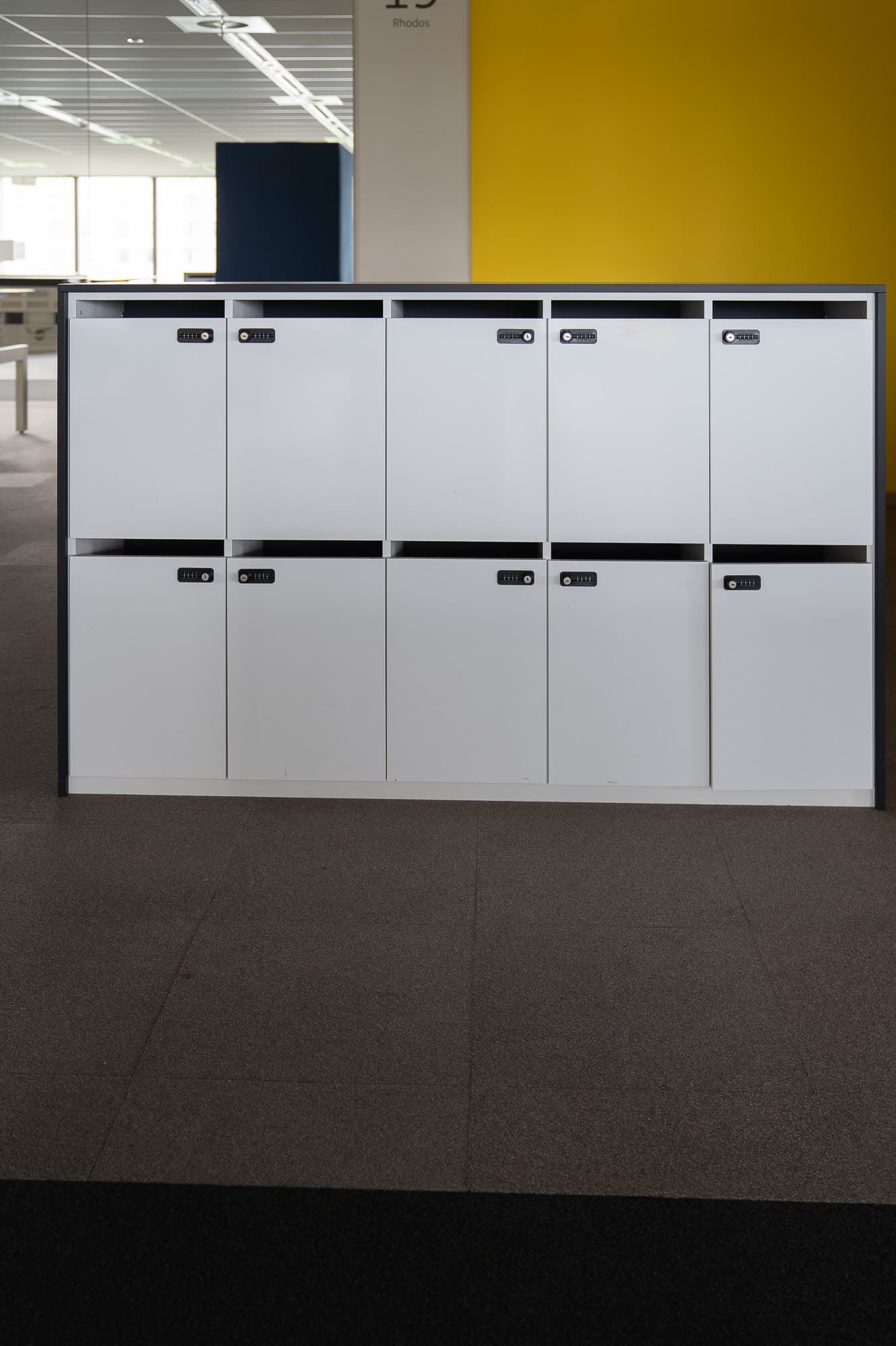 Witte lockers met meerdere compartimenten en zwarte structuur met code-0