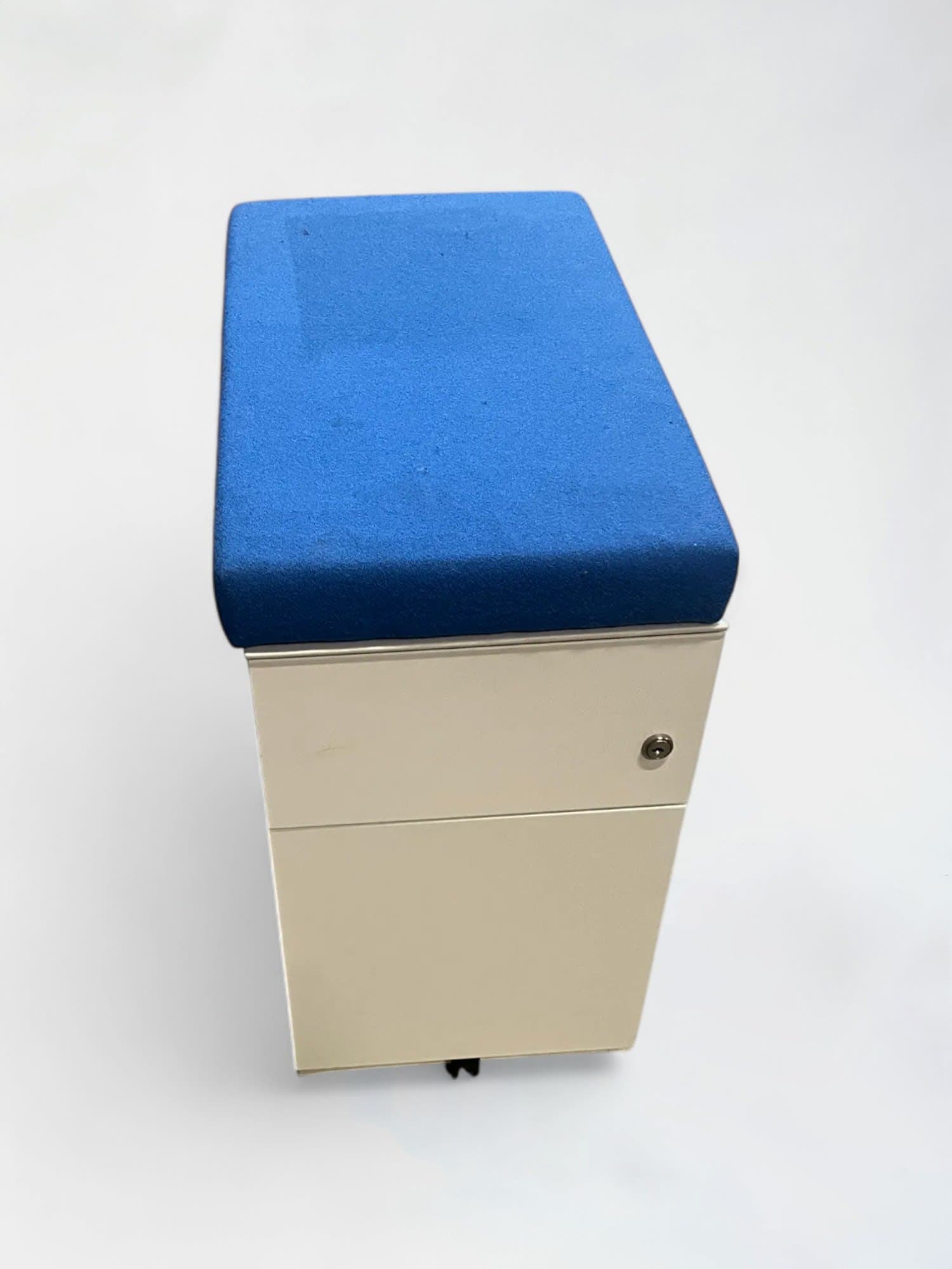 Meuble à tiroirs blanc avec dessus de coussin bleu en tissu