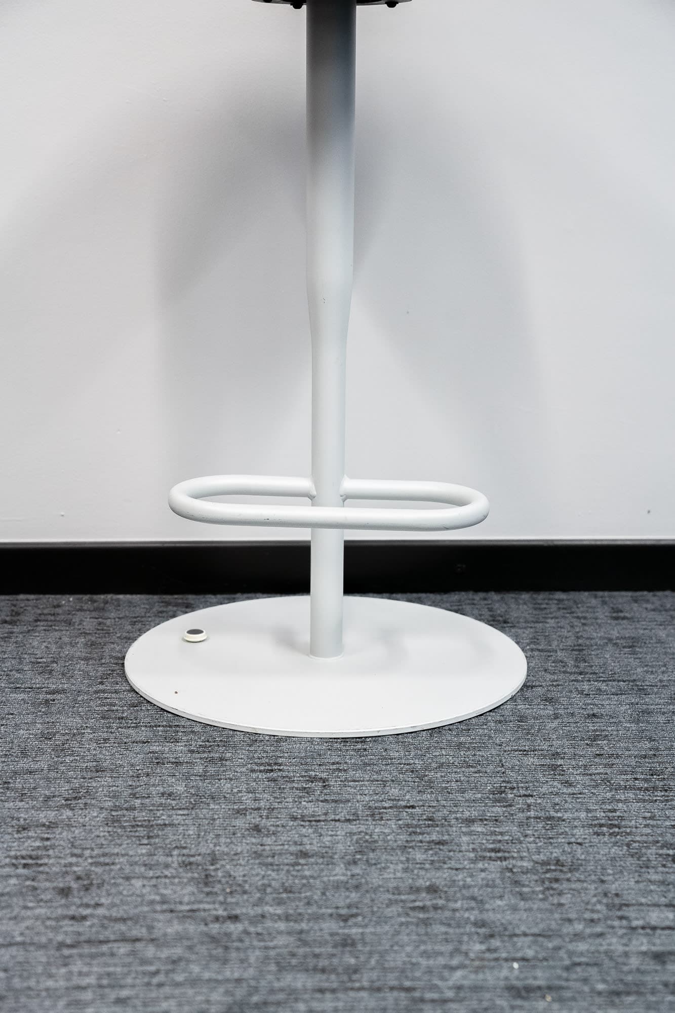 Orange rounded high stool on white legs