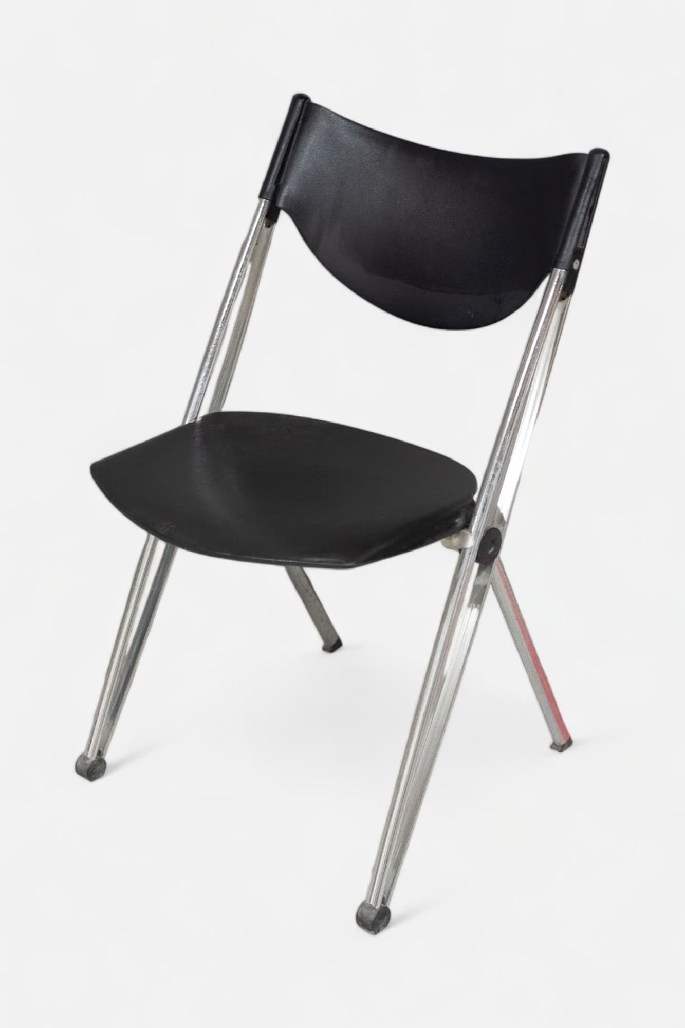 Chaise pliante en plastique noir avec pieds chromés et design ergonomique