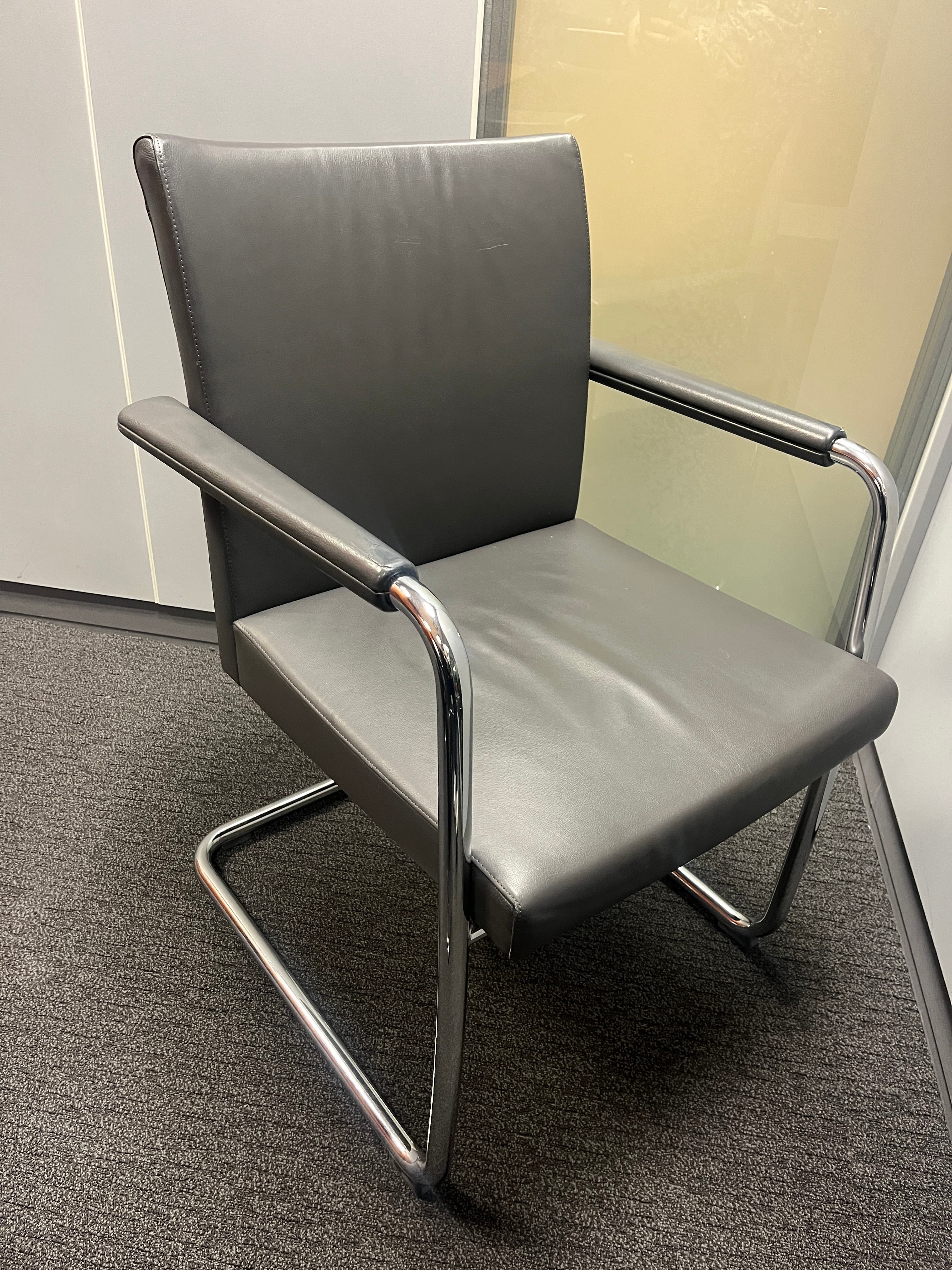 Brunner Grey leather chair with small scratches on the armrests