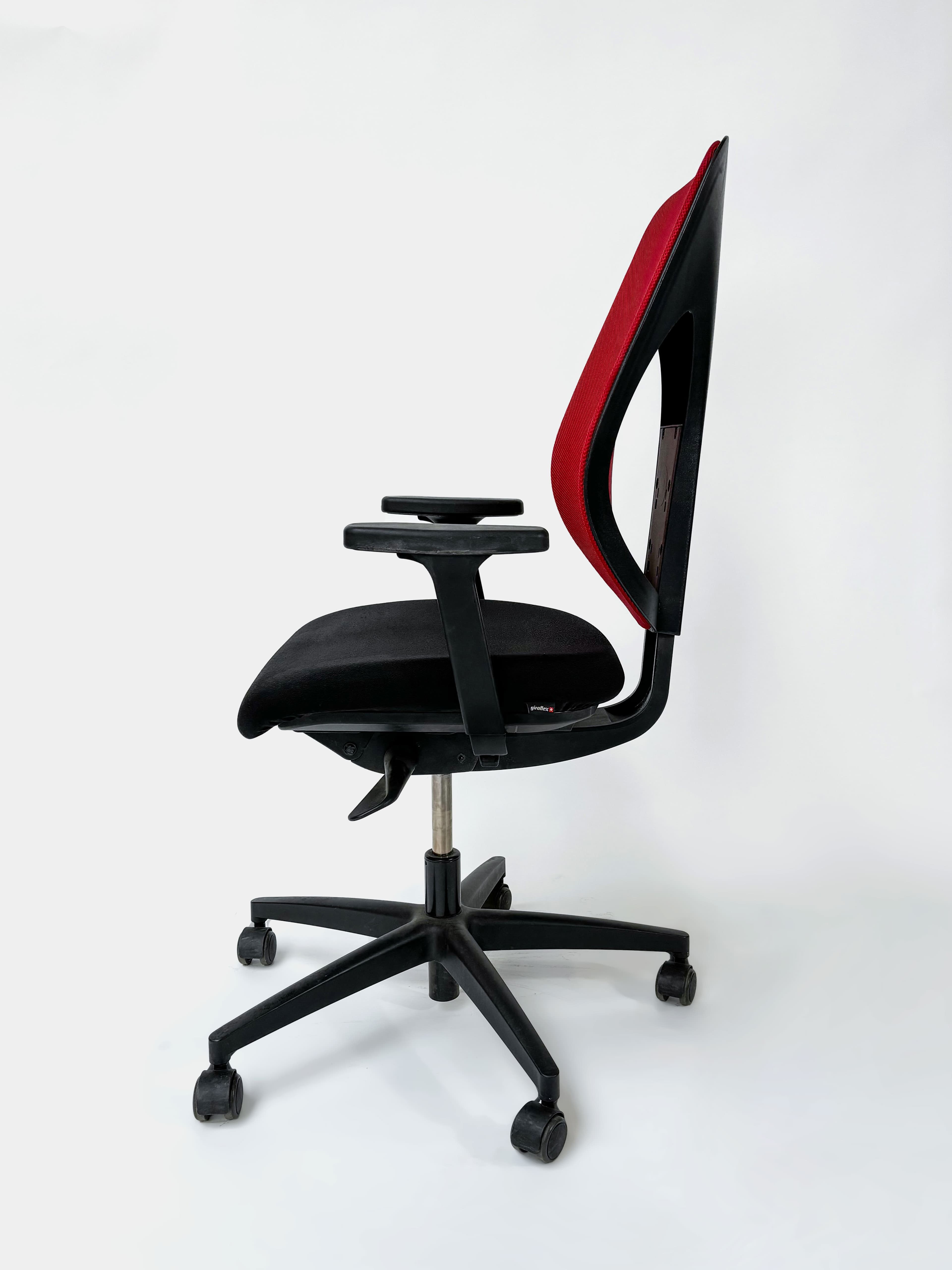 WORN: GIROFLEX Ergonomische verstelbare rode en zwarte bureaustoel op wieltjes. Functioneel maar met krassen of vlekken op de zitting.