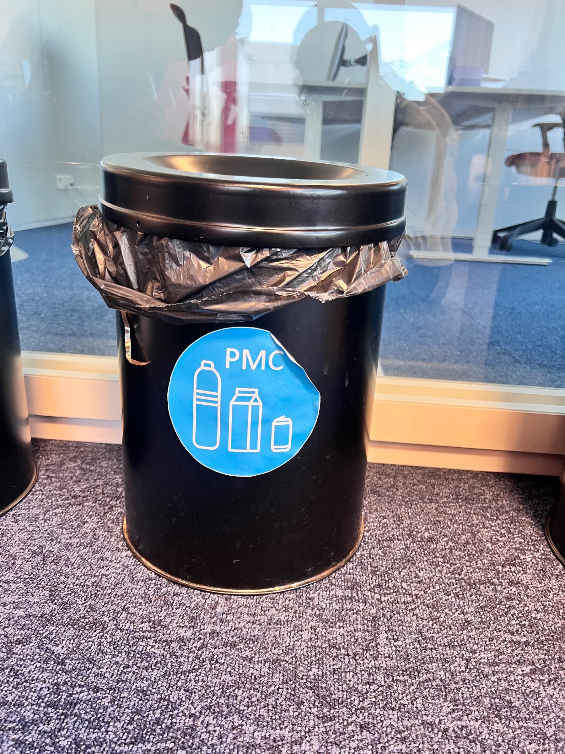 Poubelle en métal noir avec étiquette de recyclage