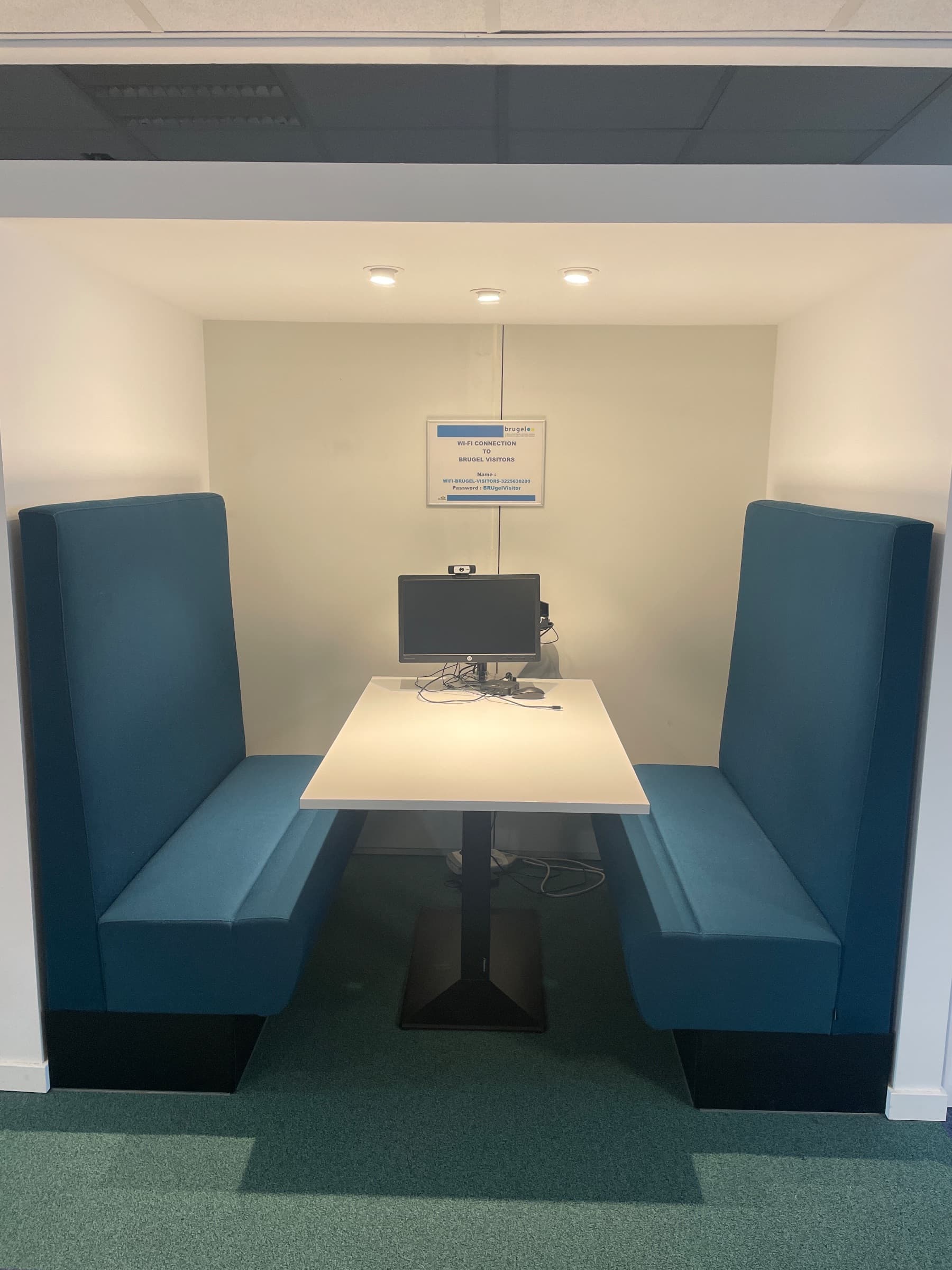 Teal stoffen vergadercabine met witte tafel en geïntegreerde technologie-2