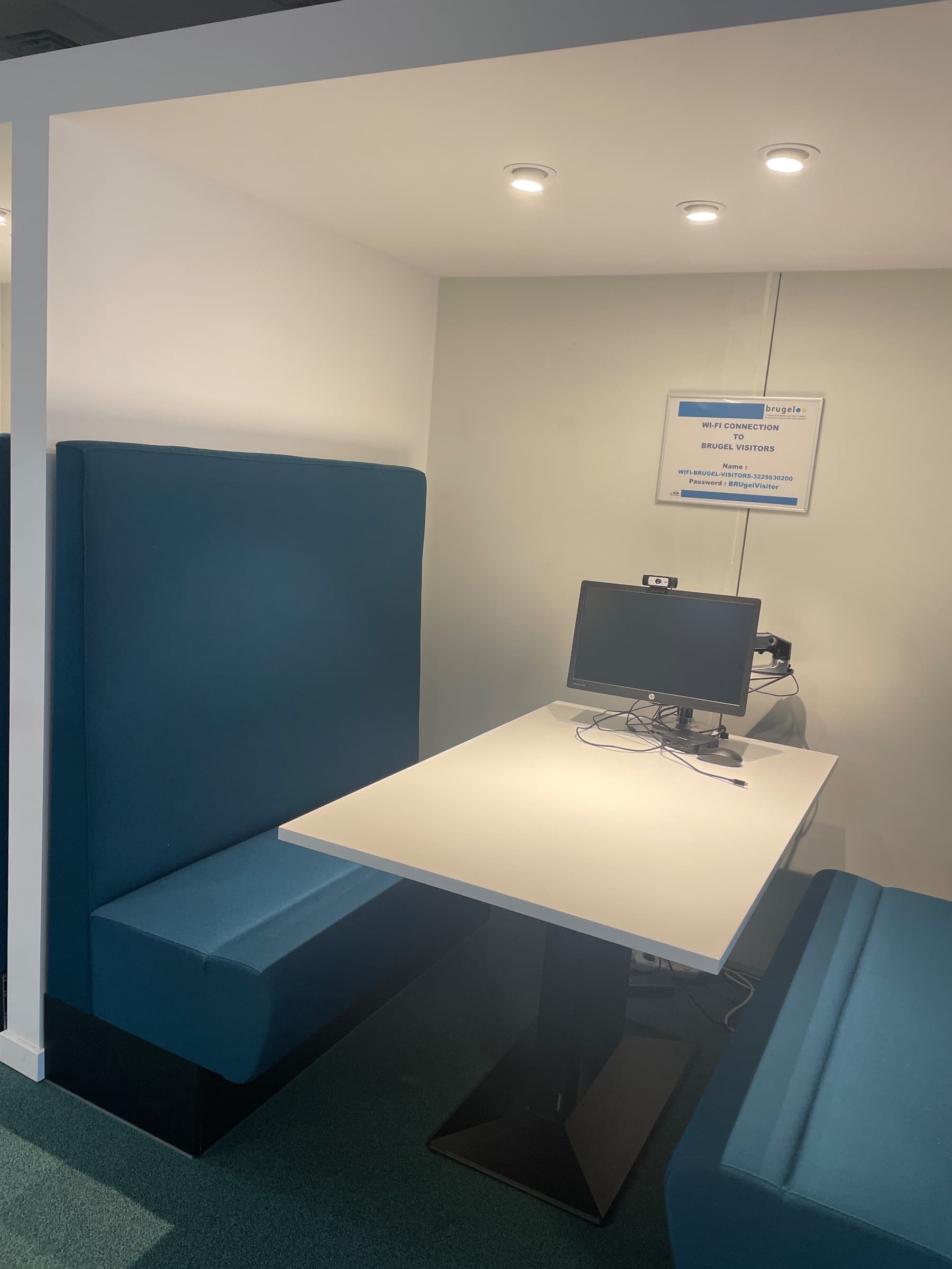 Teal stoffen vergadercabine met witte tafel en geïntegreerde technologie-1