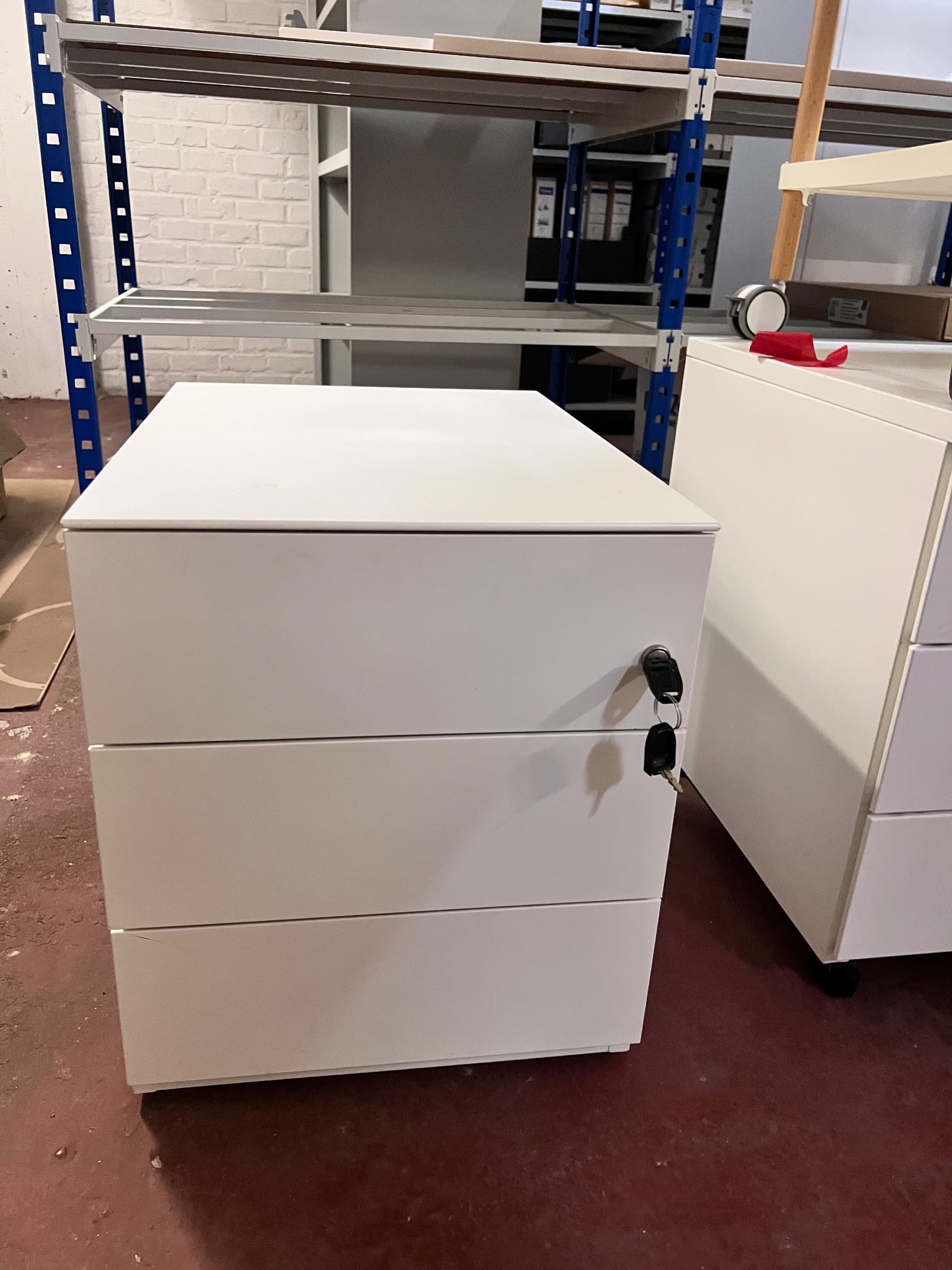 Witte metalen archiefkast met drie laden en een slot