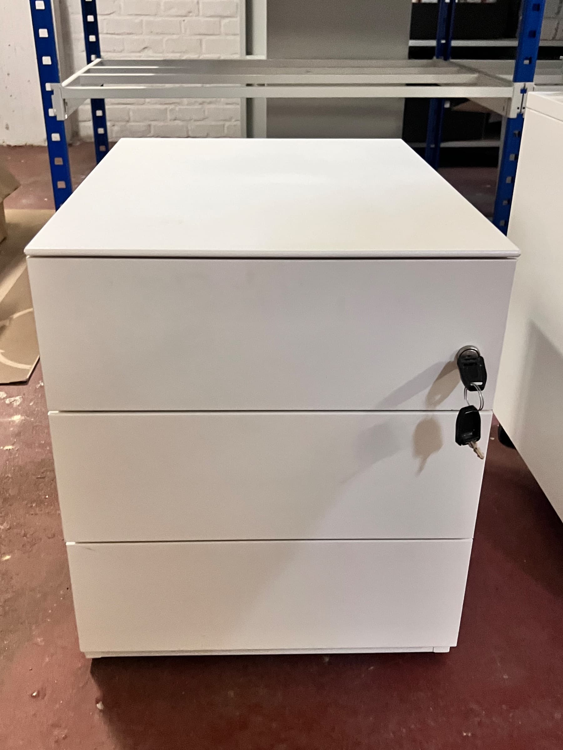 Witte metalen archiefkast met drie laden en een slot