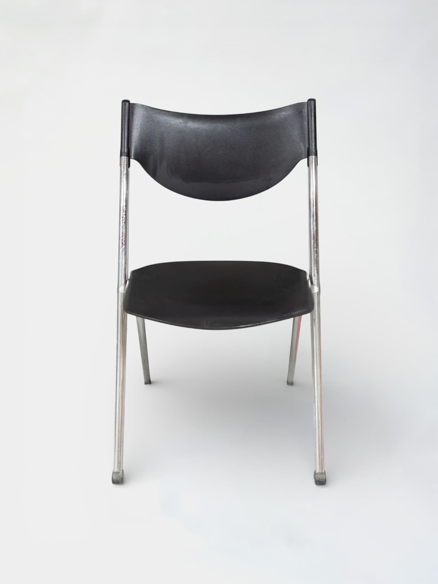 Black plastic folding chair with chrome legs and ergonomic design