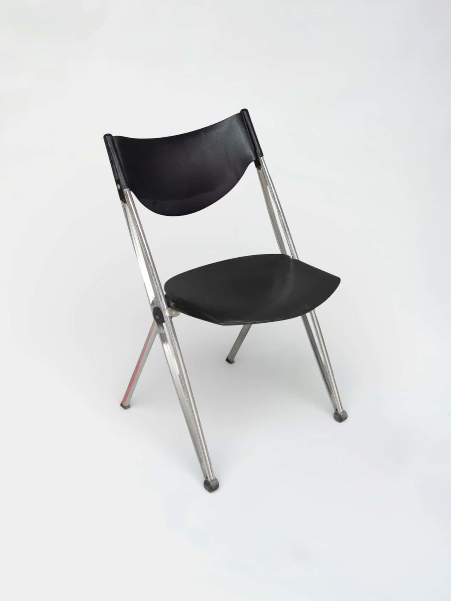 Black plastic folding chair with chrome legs and ergonomic design product image