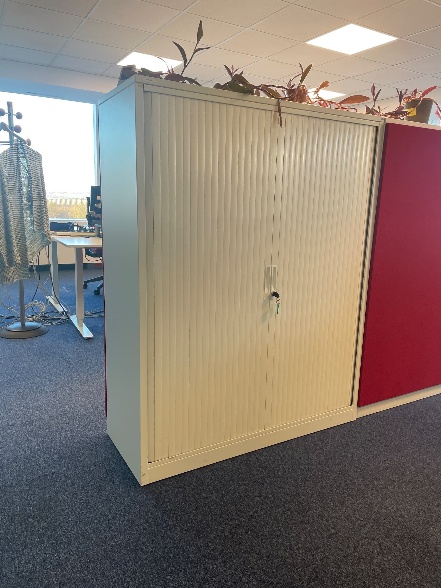 White metal storage cabinet with sliding doors with acoustic panel