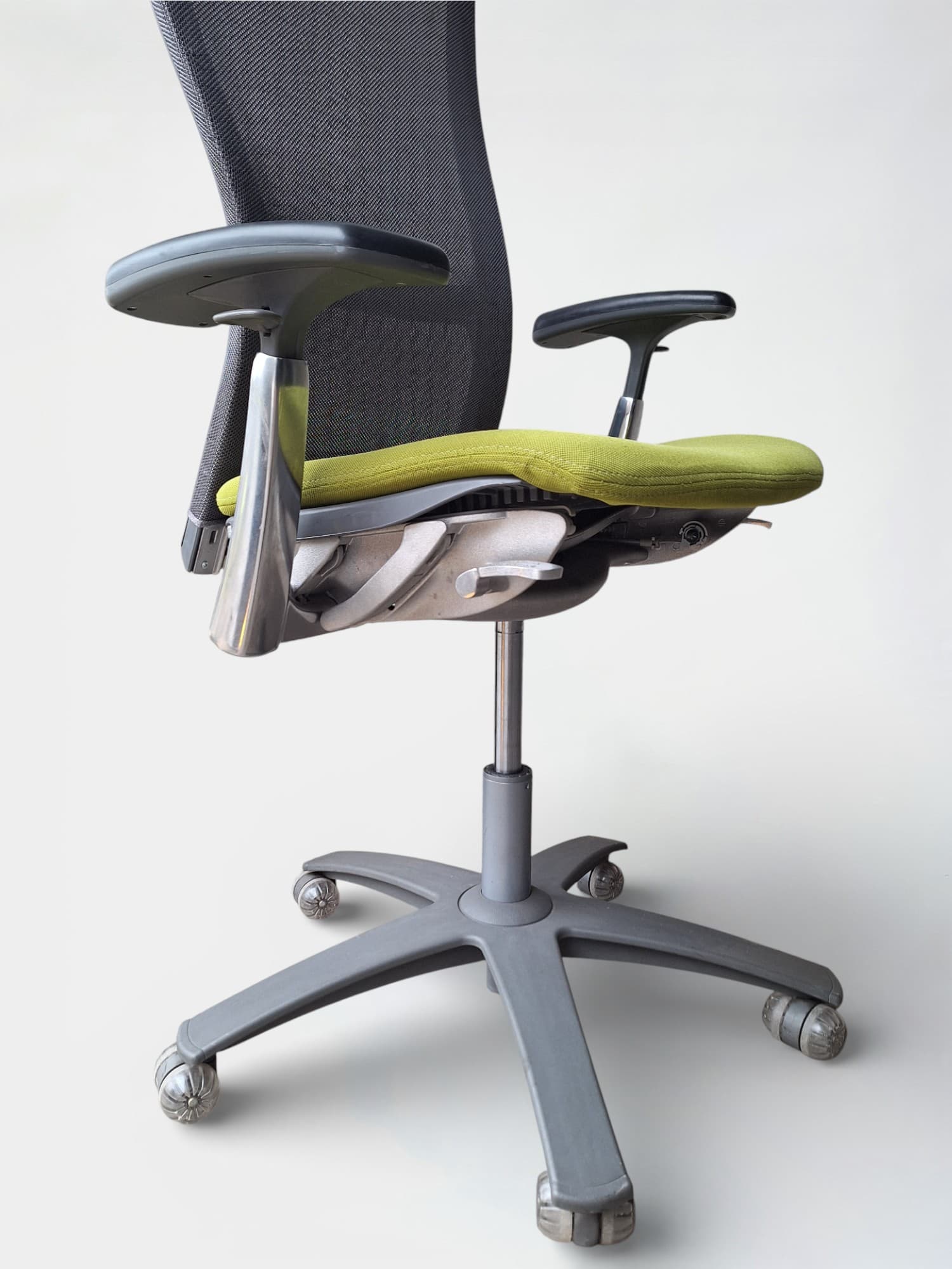 Knoll Adjustable office chair with green seat and grey mesh back on wheels